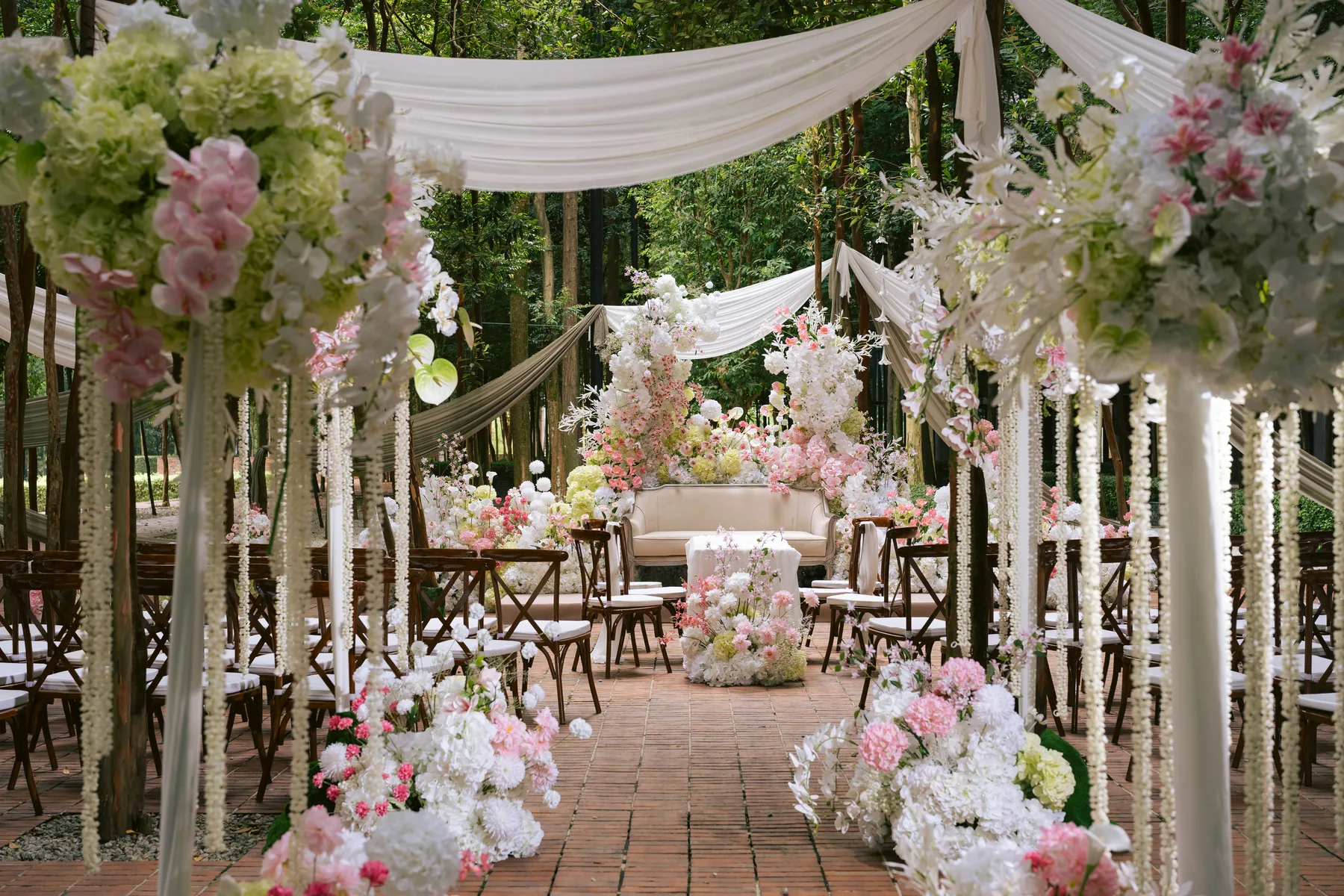 Pink garden ceremony decoration beneath tall trees